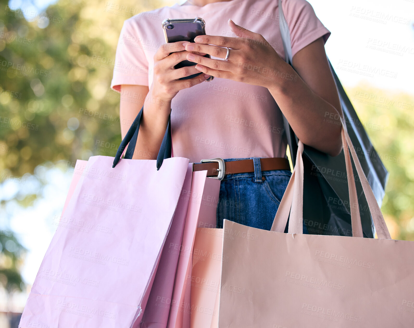 Buy stock photo Hands, phone and shopping bags with a woman customer outdoor in a park during summer for consumerism. Ecommerce, online shopping and retail with a female consumer using the internet to search a sale
