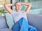 Music, headphones and woman relax on sofa in home living room streaming radio or podcast. Meditation, zen and female from Canada on couch in lounge listening to audio, song or sound in house alone.