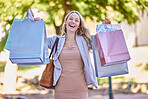 Shopping, retail and portrait of woman with shopping bag walking in city street, road and sidewalk with smile. Mall, wealth and girl shopaholic with products from sale, discount and bargain at store