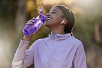 Exercise, black woman and drinking water for fitness, wellness and health outdoor to relax. Fitness, young female Nigerian and athlete hydration, liquid for break and training for workout and airpods