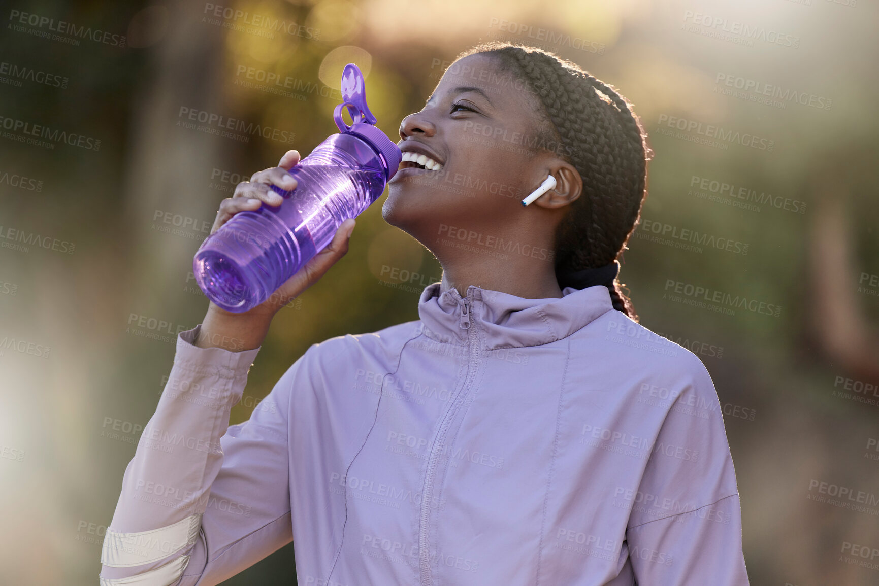 Buy stock photo Exercise, black woman and drinking water for fitness, wellness and health outdoor to relax. Sports, young female Nigerian and athlete hydration, liquid for break and training for workout and earbuds.