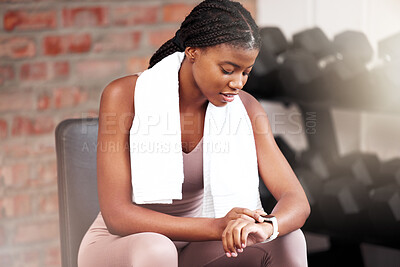 Buy stock photo Fitness, health and black woman with smart watch in gym for tracking workout, exercise or progress. Sports, tech and female athlete with towel and watch to time training or record heart rate on break
