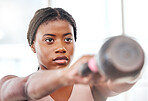 Fitness, kettlebell and black woman doing an exercise with a weight with strength, focus and motivation. Sports, exercising and strong African female athlete doing muscle training or workout at a gym