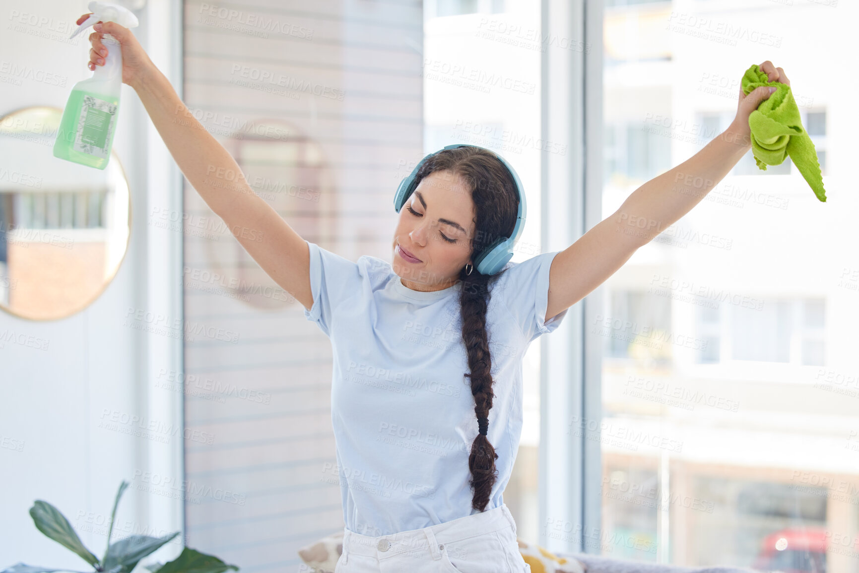 Buy stock photo Woman cleaning, dancing and listening to music with headphones while holding cloth and detergent to clean with energy, fun and audio podcast. Female cleaner or maid working in a house or apartment