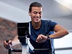 Fitness, bike and man doing workout at the gym for cardio endurance, health and wellness. Sports, electric bicycle and healthy male athlete training or doing exercise with smart watch in sport center