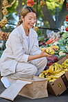 Bananas, shopping and Asian woman at outdoor market buying delicious and healthy fruits. Plantains, products and female from Japan purchasing fruit at street stall for vitamin c, health and wellness.