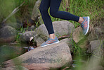 Fitness, legs or shoes running in nature for training, cardio exercise or workout by a river, water or lake in Amsterdam. Footwear, sneakers or healthy sports girl runner in running shoes on a rock