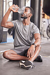 Black man drink water, fitness and gym with challenge workout training for muscle and thirsty with motivation, goals and sweating. Tired sports, athlete person with water bottle in health exercise