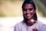 Party, birthday and woman with sparkle in hand for Christmas, festival celebration and new years. Light, fireworks and girl holding sparkler to celebrate holiday, vacation and festive event in nature