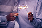 Sparklers, hands and couple celebration with lights, sparks and magic for new years evening, love and anniversary. Closeup man, woman and people celebrate with sparkles, fireworks and glow with shine