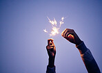 Sparkler, hand andperson at night for new years eve celebration with bright, burning fun to celebrate. Celebrating, sparkle and blue nighttime background with a firework or firecracker in hands