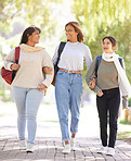 Diversity, women and students outdoor, walking and conversation on break, relax and smile. Young females, girls and in nature for peace, bonding together and stroll on pathway, casual and trendy look