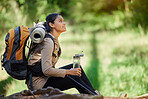 Black woman, hiking and rest sitting in nature, woods or forest for goal, motivation or outdoor adventure. Woman hiker, water bottle and tired on trail for wellness, fitness or trekking in California