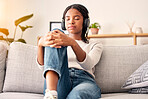 Music headphones, peace and relax girl listening to wellness podcast for calm mindset, mindfulness or audio meditation. Easy meditating, living room sofa or gen z black woman streaming zen radio song