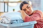 Woman, laundry basket and sleep while tired, relax or rest in living room after cleaning, wash and packing. Housewife, cleaner and sleeping with clothes, fabric and fatigue from housework in Mexico