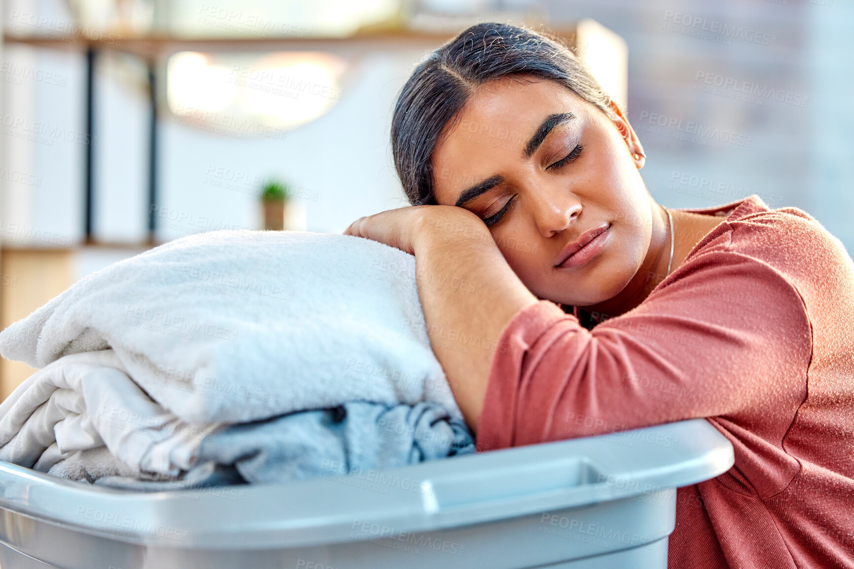 Buy stock photo Woman, laundry basket and sleep while tired, relax or rest in living room after cleaning, wash and packing. Housewife, cleaner and sleeping with clothes, fabric and fatigue from housework in Mexico