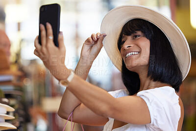 Buy stock photo Woman, fashion and selfie with a phone while happy at a mall buying a hat with a smile for shopping, happiness and travel as tourist. Female with smartphone at market for social media sale post