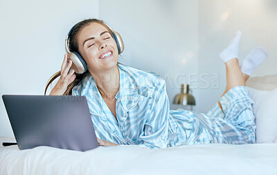 Buy stock photo Headphones, laptop and woman on her bed with music for mental health, relax and wellness in morning sunshine or lens flare. Happy woman or student on internet, audio streaming subscription in bedroom