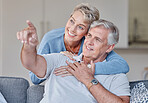 Senior couple, bonding or hand pointing on sofa in Australia house or home living room in future planning or life insurance strategy. Smile, happy man or retirement elderly woman with showing gesture