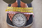 Top view, feet on scale and tape to lose weight, health and diet for wellness, balance and fitness. Obese, measure and results after training, healthy lifestyle or commitment to exercise and weighing
