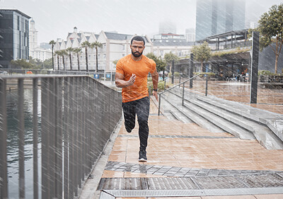 Buy stock photo City fitness, man and running in rain for exercise, body workout and cardio training. Portrait, wet and urban runner with focus, motivation and strong motivation for sports, power and marathon energy