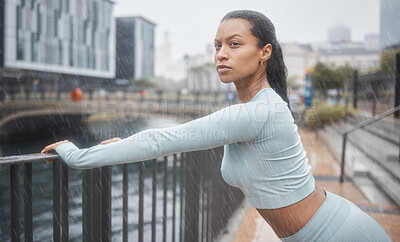Buy stock photo Workout, stretching or black woman runner training for mindset focus running in the rain. Wellness, health athlete and sports exercise in winter of girl for motivation in the city for fitness warm up