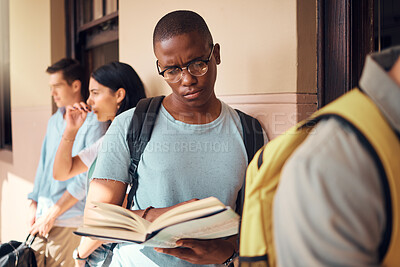 Buy stock photo University, education and black man reading a book in the campus hallway waiting for class. Focus, learning and African male student studying with a textbook in the corridor before a test at college.