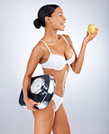 Black woman, scale and apple for healthy lifestyle, diet or wellness on grey studio background. African American  female, girl or fruit for health, body care or nutrition to lose weight or healthcare