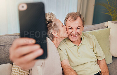 Buy stock photo Senior, kiss and phone selfie of a couple with love, care and happiness on a living room sofa. Happy, smile and marriage of a wife and man together on wifi with mobile phone photo for social media