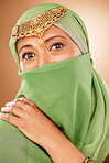 Fashion, tradition and face of a muslim woman in studio with traditional jewelry and burka. Beauty, islam and portrait of mature lady with islamic hijab scarf or arabic jewellery by brown background.