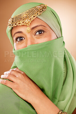 Buy stock photo Fashion, tradition and face of a muslim woman in studio with traditional jewelry and burka. Beauty, islam and portrait of mature lady with islamic hijab scarf or arabic jewellery by brown background.