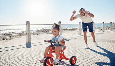 Buy stock photo Ocean, bicycle and happy father with girl excited after learning, teaching and helping kid ride bike. Black family, love and dad celebrate with child on summer holiday, vacation and weekend by sea