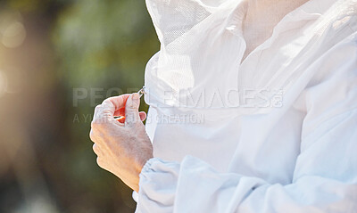 Buy stock photo Hand, zip and beekeeper uniform with a farm woman outdoor in the countryside for organic sustainability. Agriculture, farmer and beekeeping with a female agricultural working zipping up for safety