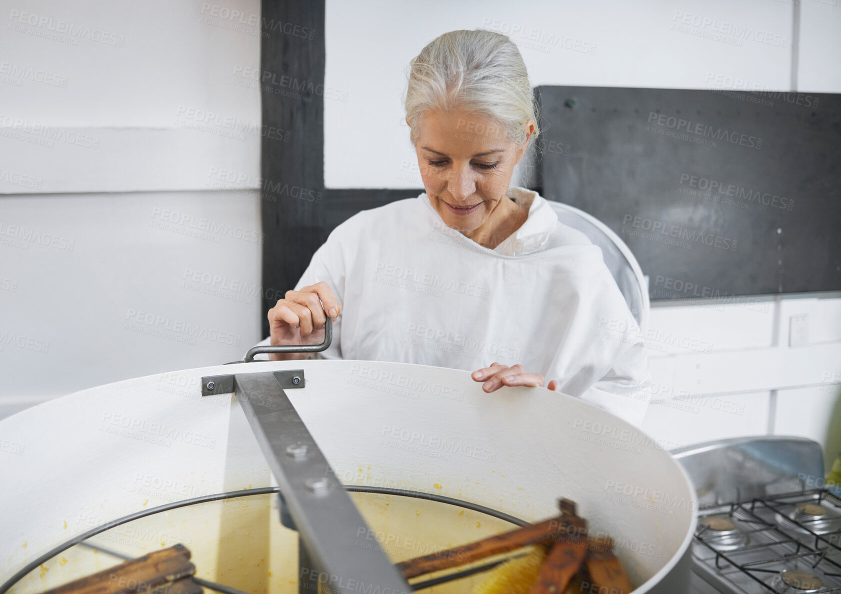 Buy stock photo Beekeeper woman, factory and honey production with machine, focus and working in apiculture industry. Senior bee expert, harvesting process and extractor for job at agriculture warehouse in Florida