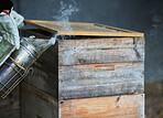 Beekeeping, smoke and wood box for bee farming with smoker tools for process to calm for maintenance and harvest of honey bees. Hand of beekeeper for manufacturing and production of honeycomb