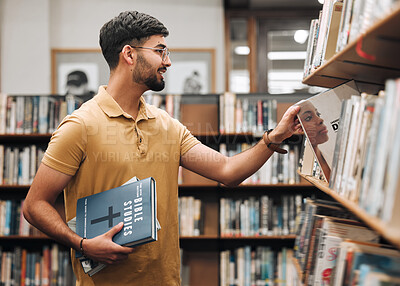 Buy stock photo University, student or man with bible in a library to study spiritual religion knowledge, prayer or Christ bookshelf search. Smile, school or happy man in college studying or worship research in God
