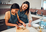 Mother, girl and kitchen for teaching, cookies and learning for baking, bonding and love in family home. Woman, daughter and cooking for festive food, holiday or celebration for christmas in house