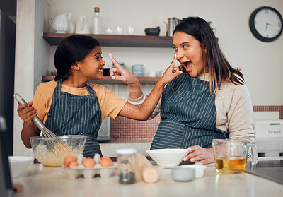 Buy stock photo Baking, family and children with a mother and daughter learning hot to bake while being playful in the kitchen. Fun, kids and food with a girl and woman teaching a female child about cooking together