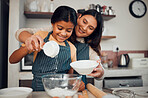Baking, children and kitchen with a mother and daughter learning about cooking or food in their home together. Family, love and bonding with an indian woman teaching her female child how to bake