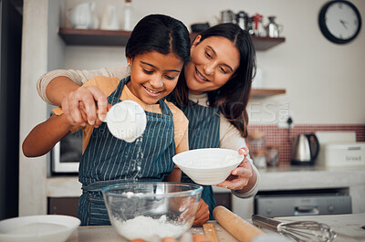 Buy stock photo Baking, children and kitchen with a mother and daughter learning about cooking or food in their home together. Family, love and bonding with an indian woman teaching her female child how to bake