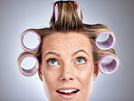 Hair, rollers and beauty with a model woman in studio on a gray background for a hairstyle using curlers. Hair care, thinking and face with an attractive young female styling her curly extensions