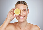 Woman, lemon and natural skincare portrait for glow, beauty wellness and luxury citrus fruit treatment in grey studio background. Happy, model smile and vitamin c dermatology or spa facial nutrition
