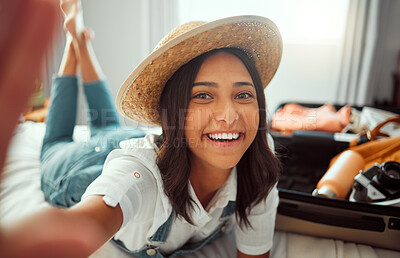 Buy stock photo Face, travel selfie and woman packing suitcase getting ready for vacation or holiday. Portrait, relax and happy female taking pictures in hat while loading luggage on bed in preparation for trip.