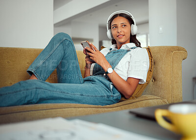 Buy stock photo Relax, phone and woman on a sofa with music, radio and online entertainment in a living room, happy and content. Podcast, student and girl with smartphone on a couch, rest and break in Brazil home