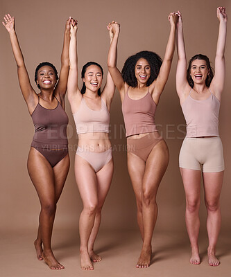 Buy stock photo Diversity, women and natural beauty friends in studio in brown background with hands raised in celebration and support together. Diverse woman, underwear and celebrate body care or healthy lifestyle