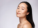 Skincare, dermatology and woman with beauty, cosmetic marketing and smile for body glow on a studio background with mockup space. Makeup, wellness and portrait of an Asian model advertising cosmetics