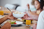 Food, lunch and hands pass bowl with delicious pasta at home. Brunch, fine dining and family or people eating and sharing a delicious, gourmet and healthy meal on table together in house dinning room