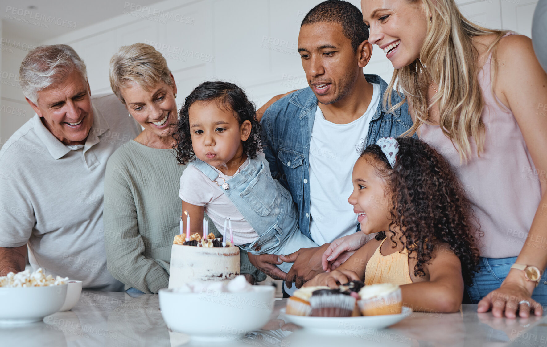 Buy stock photo Big family, birthday cake and blowing candles for a wish at home with parents, grandparents and children together for a celebration. Men, women and kids in UK house to celebrate at party for a girl 