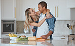 Cooking, love or couple hug in a kitchen with healthy food diet in an interracial relationship or marriage at home. Carrot, vegetables or happy woman hugging romantic partner preparing a dinner meal