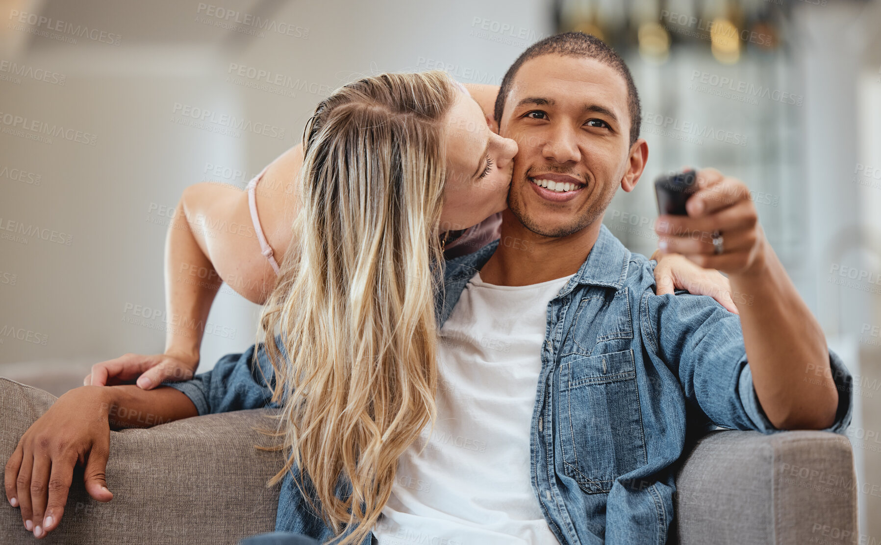 Buy stock photo Couple, sofa and woman with cheek kiss for man, partner or husband with love, romance and care in home. Girl, surprise  and kissing face of black man for bonding, happiness and relationship on couch